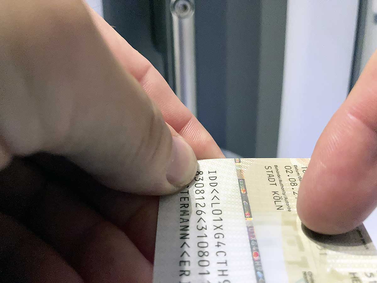 Der silberne Kunststoffstreifen auf der Rückseite des Personalausweise glänzt in Regenbogenfarben